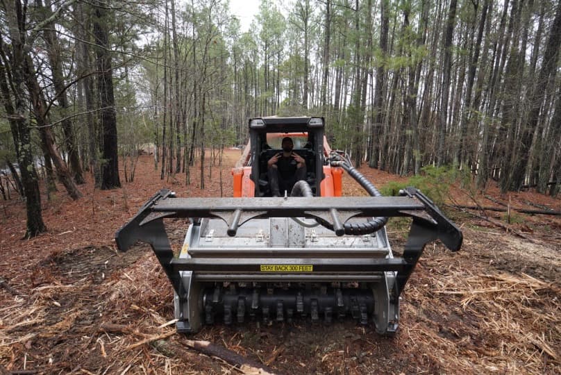 Forestry mulcher head-on view preparing a property for site clearing